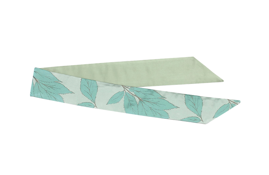Light green silk Mimi Fong skinny scarf with leaves pattern on white background