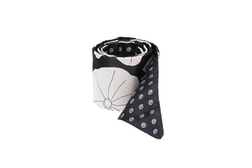 Rolled black & white silk Mimi Fong skinny scarf with lily pad pattern on white background
