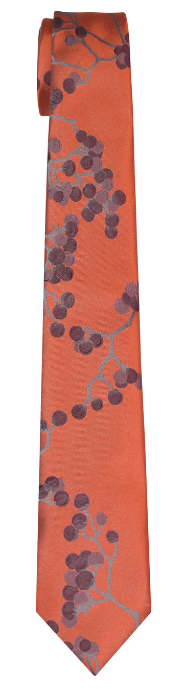 An orange silk Mimi Fong tie with all over berries pattern in hues of burgundy against a white background