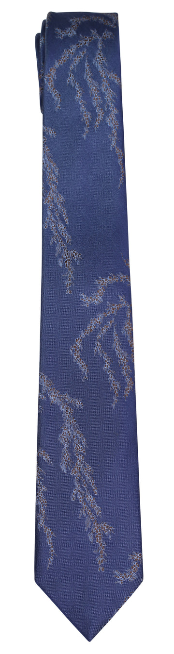 A blue silk Mimi Fong tie with seaweed pattern against a white background