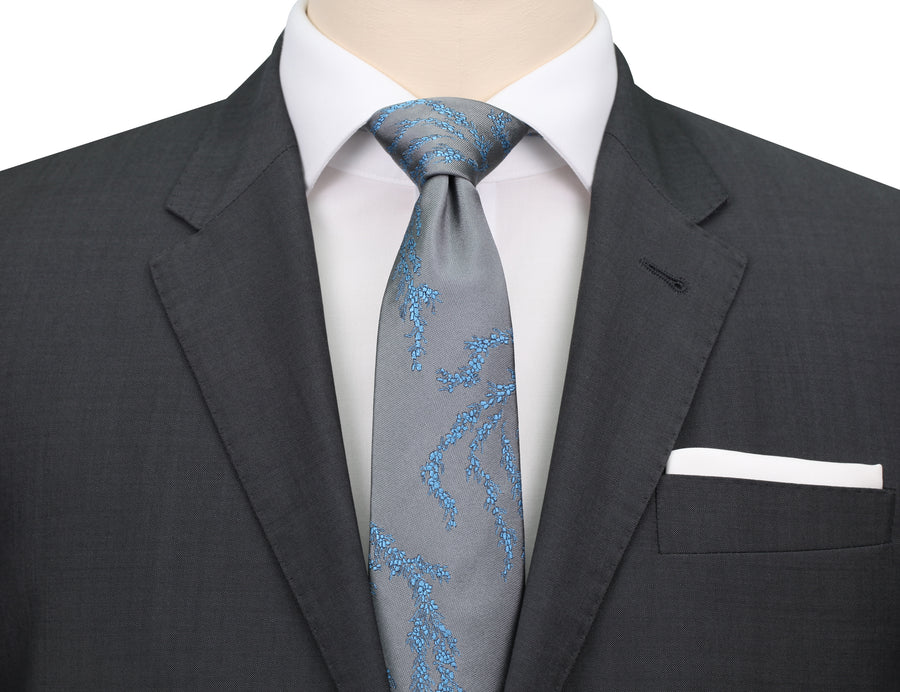 Mannequin wearing grey suit, white shirt and a grey silk Mimi Fong tie with light blue seaweed pattern against a white background